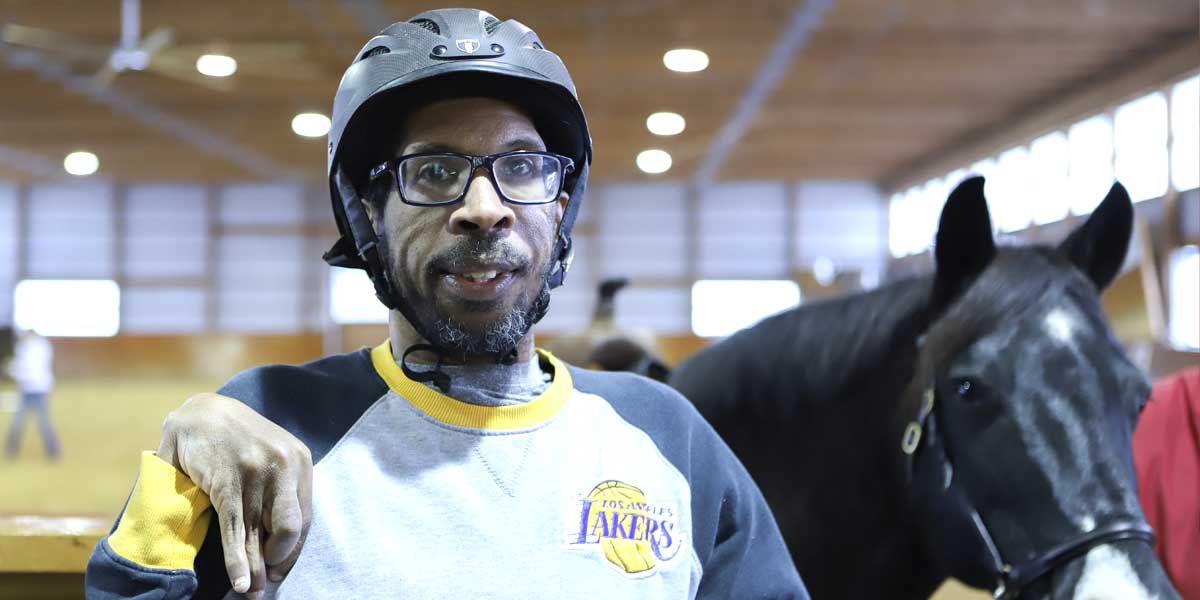 Man participating in therapeutic horseback riding